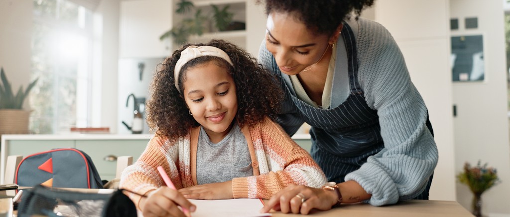 une mère aide sa fille à faire ses devoirs.